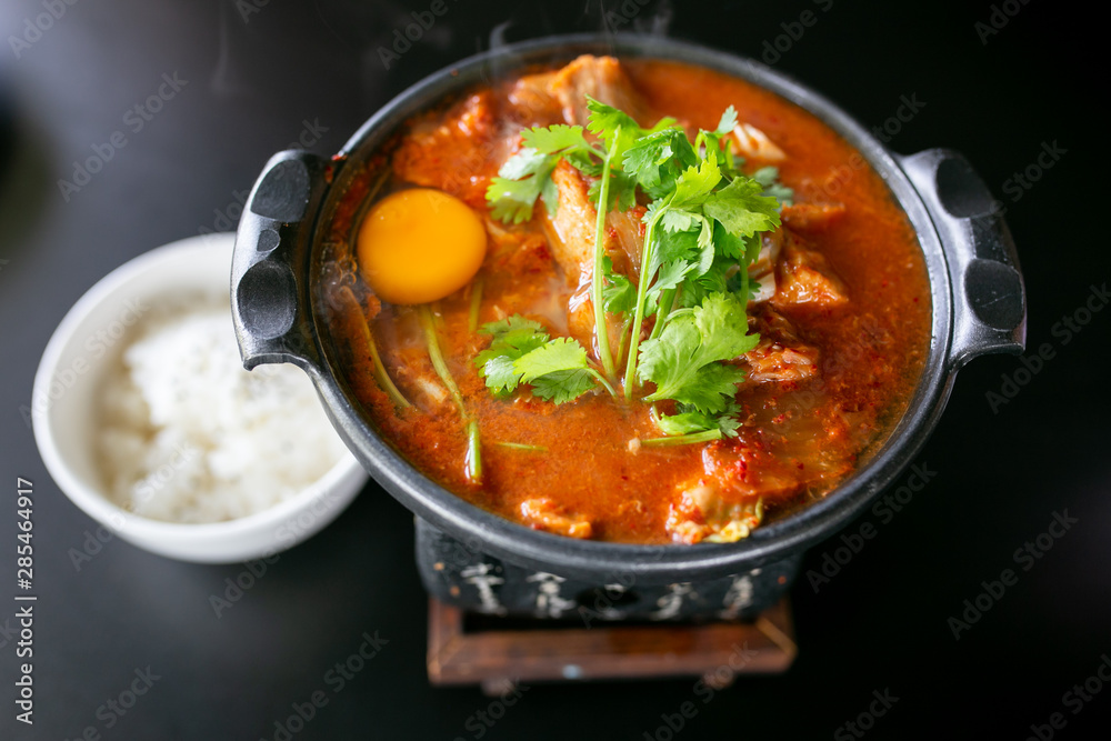 Kimchi soup with raw chicken eggs and white tofu, popular Korean food. Kimchi soup with raw chicken eggs and white tofu, popular Korean food.