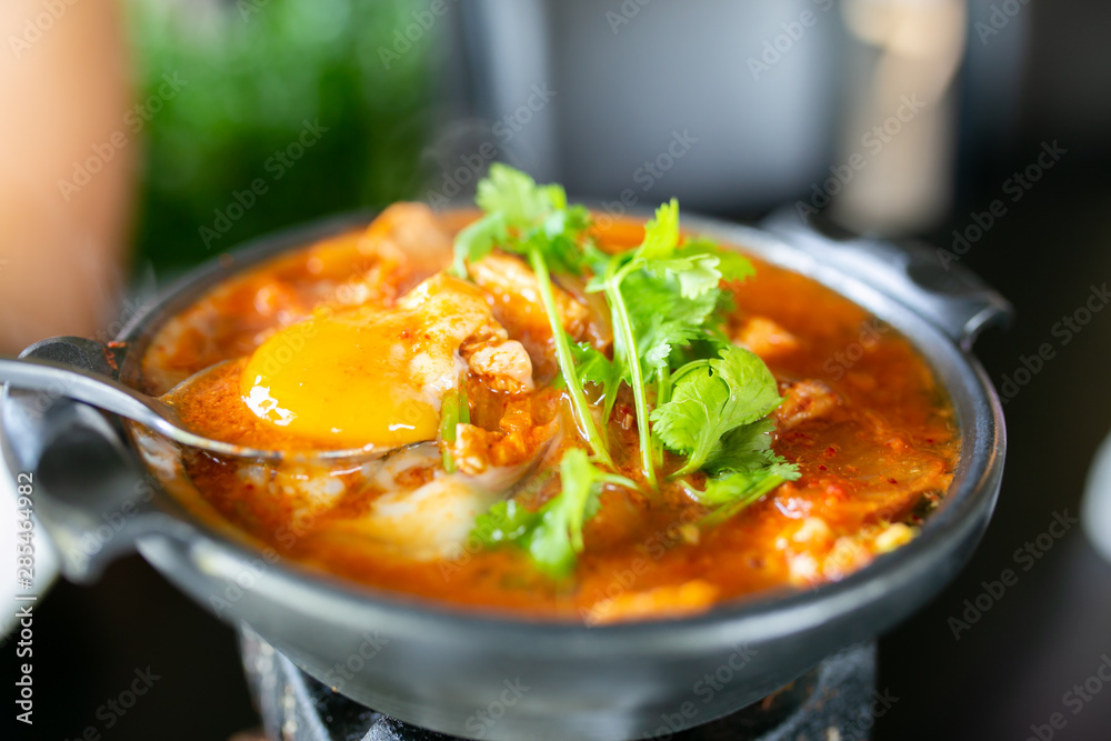Kimchi soup with raw chicken eggs and white tofu, popular Korean food. Kimchi soup with raw chicken eggs and white tofu, popular Korean food.