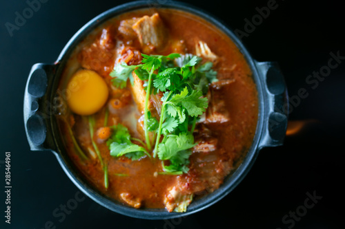 Kimchi soup with raw chicken eggs and white tofu, popular Korean food.