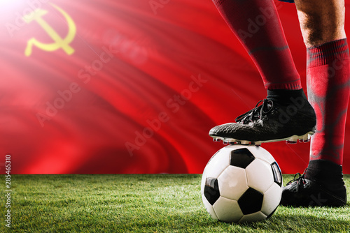 Close up legs of Soviet Union football team player in red socks  shoes on soccer ball at the free kick or penalty spot playing on grass.