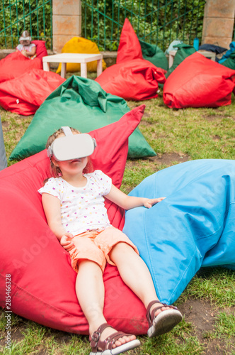 Little girl wearing virtual reality glasses. Future technology concept.