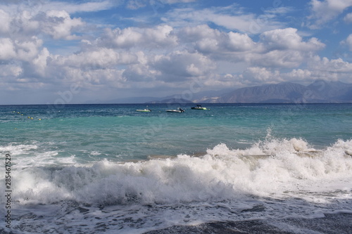 Beautiful view of the turquoise near the shore and deep blue sky, with boats, Crete, Greece