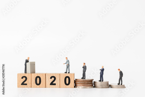 Miniature people : Business people standing on wooden block number 2020 , Happy new year concept