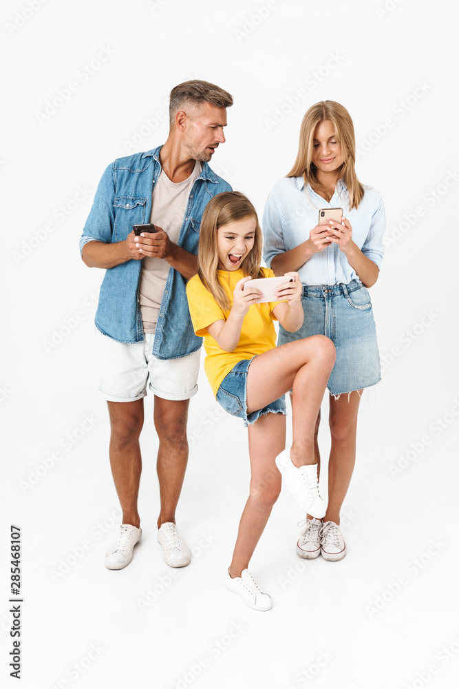 Cheerful family wearing casual outfit standing isolated Cheerful family wearing casual outfit standing isolated