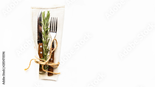 Simple laconic design cutlery on linen napkin on white table. Concept of natural organic eating. Copy space.