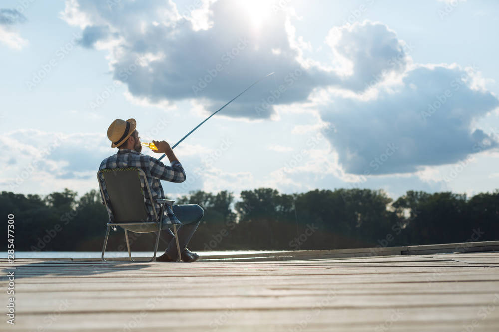 Businessman fishing and drinking beer on day off Businessman fishing and drinking beer on day off