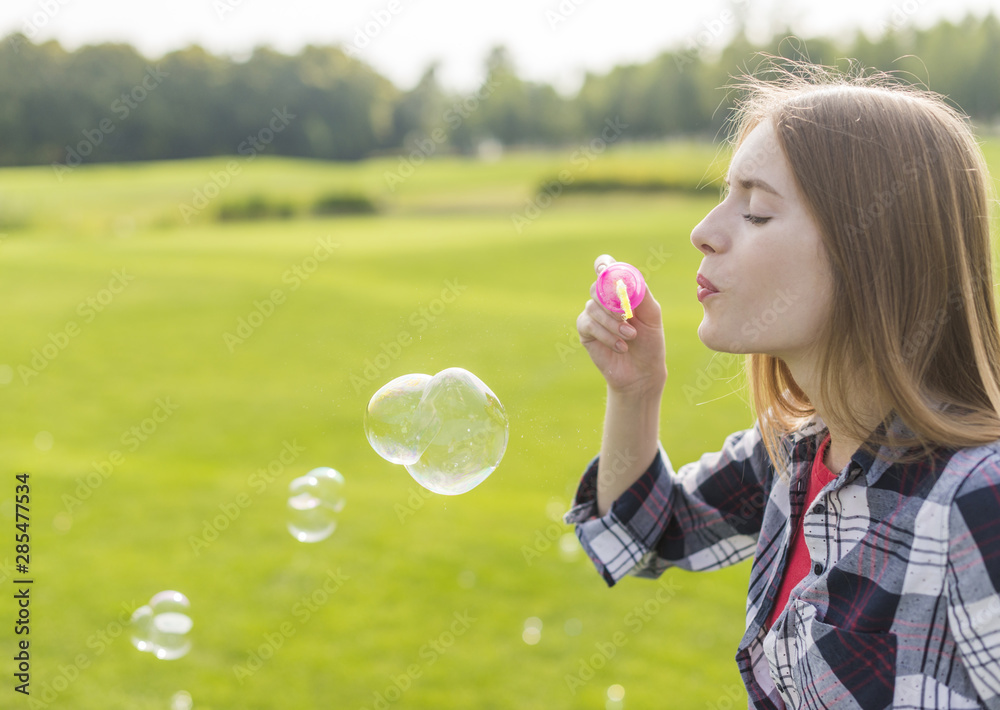 Side view blonde girl making bubbles Side view blonde girl making bubbles