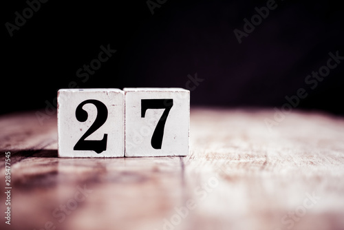 Number 27 isolated on dark background- 3D number twenty seven isolated on vintage wooden table