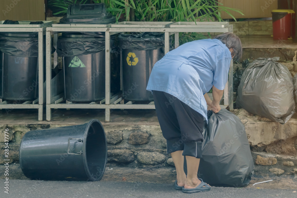 Female worker sort the garbage and packed in black bags for transportation convenience. Female worker sort the garbage and packed in black bags for transportation convenience.