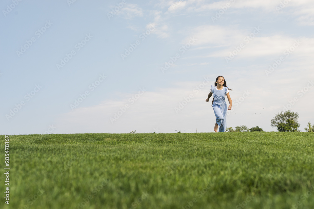 Front view girl walking barefoot on grass