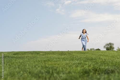 Front view girl walking barefoot on grass