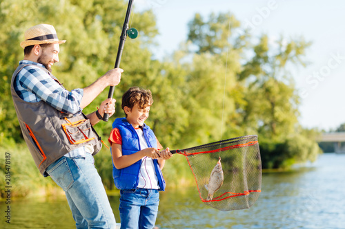 Canvas Print Man feeling happy after catching fish with his beaming son