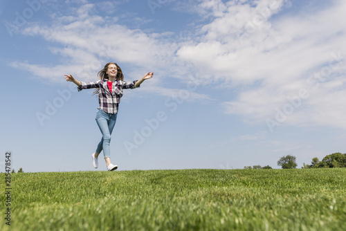Long shot cute girl running on grass