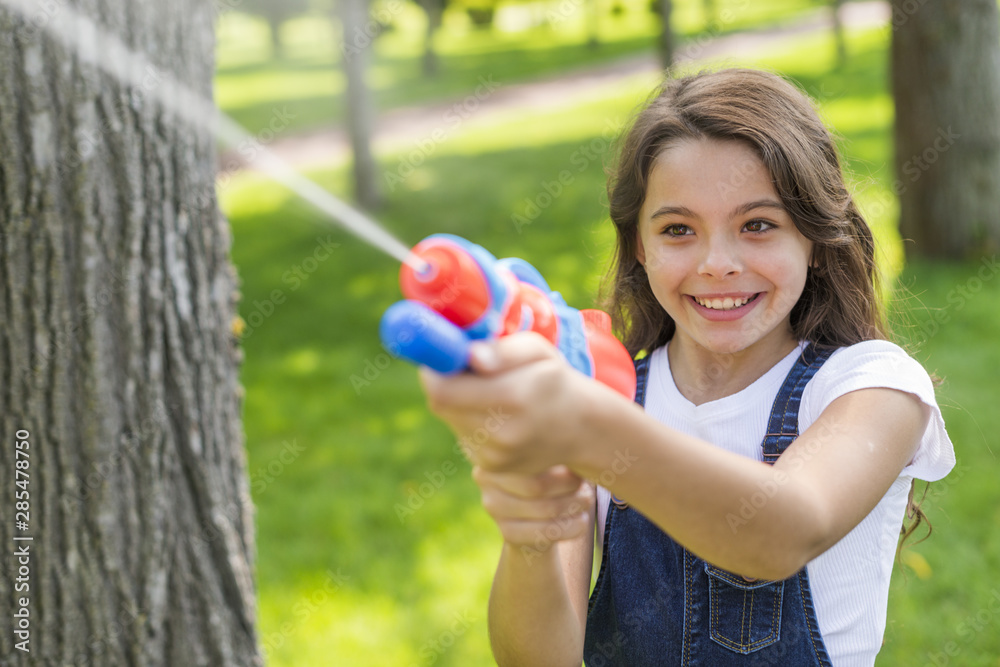 Cute girl playing with a water gun Cute girl playing with a water gun