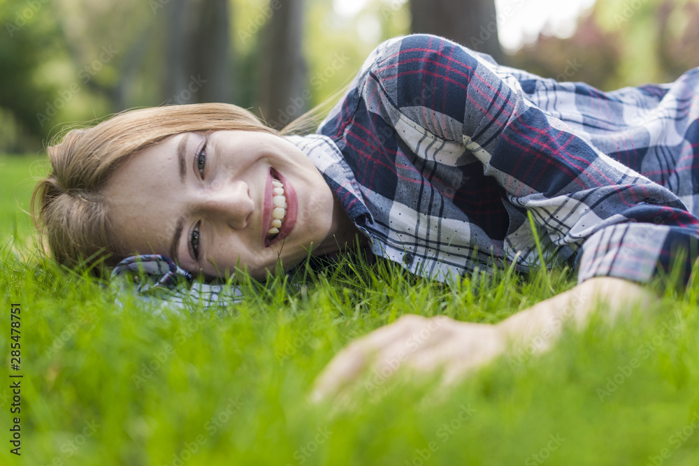 Smiley girl looking at camera while staying on grass Smiley girl looking at camera while staying on grass