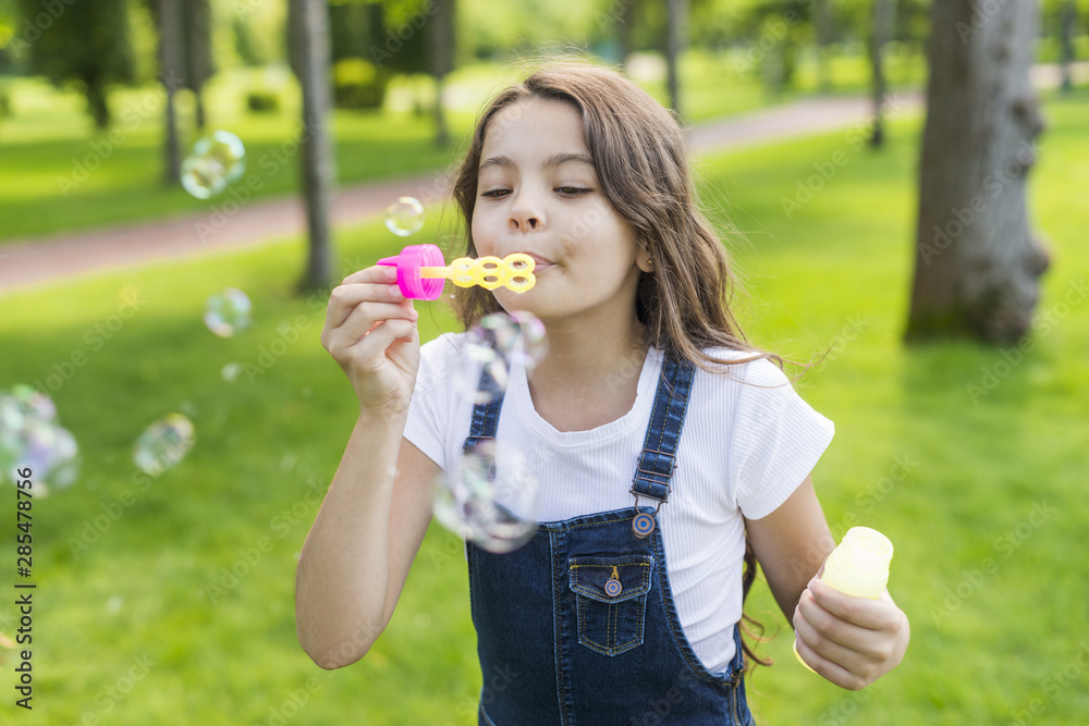Front view cute little girl making soap bubbles Front view cute little girl making soap bubbles
