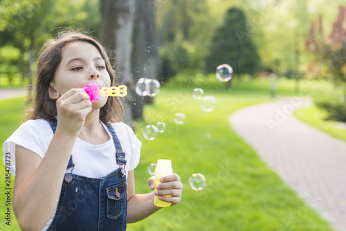 Cute little girl making soap bubbles