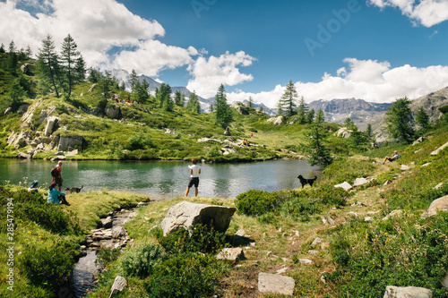 Mountain lake landscape with people near Bellagarda lake. Sense of freedom. Gran Paradiso National Park, Ceresole Reale, Piedmont, Italy © Codegoni Daniele