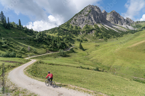 nice and active senior woman, riding her e-mountain bike in the Tannheim valley on the trail up to Litnis Schrofen , Tirol, Austria,  © Uwe