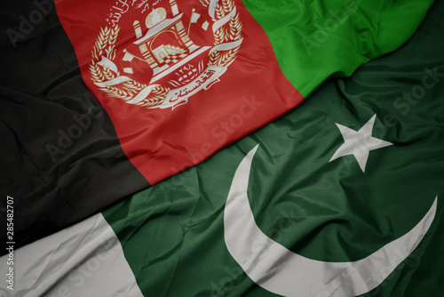 waving colorful flag of pakistan and national flag of afghanistan.