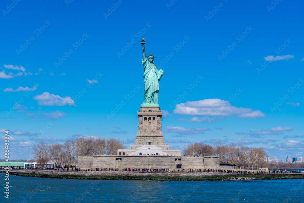 The Statue of Liberty in New York City. Statue of Liberty with blue sky over hudson river on island. Landmarks of lower manhattan New York city.