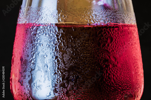 Detail of glass with red drink, cold, drops, background
