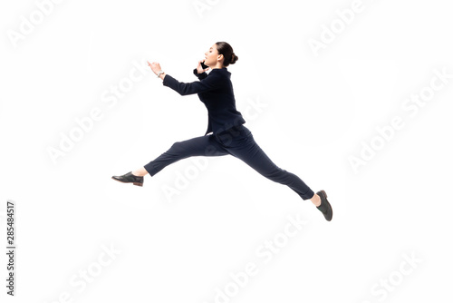 beautiful businesswoman levitating while talking on smartphone isolated on white
