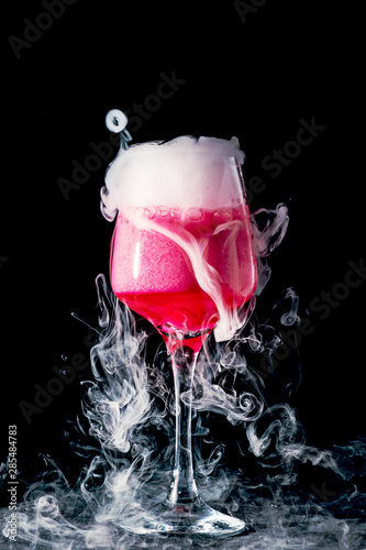 Glass with pink drink and dry ice smoke, bubbles, background