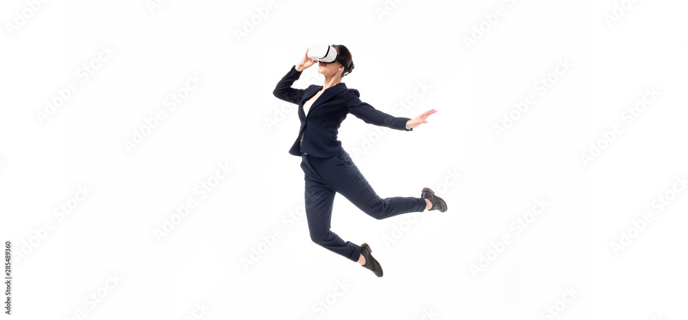 panoramic shot of businesswoman in virtual reality headset levitating isolated on white