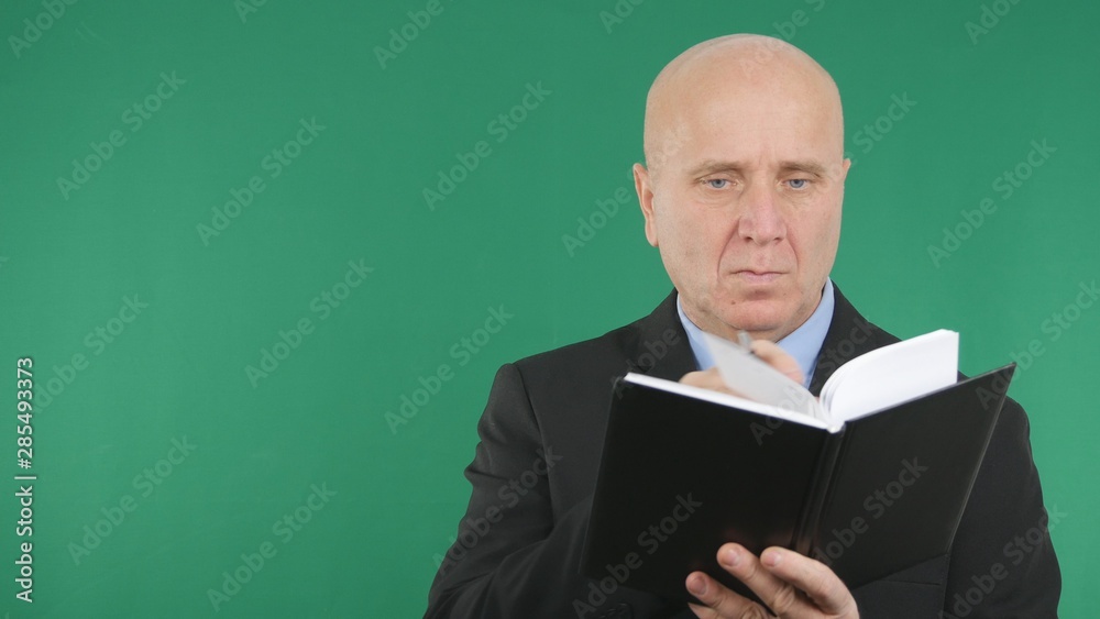 Confident Businessman Image Taking Notes in a Black Agenda Confident Businessman Image Taking Notes in a Black Agenda