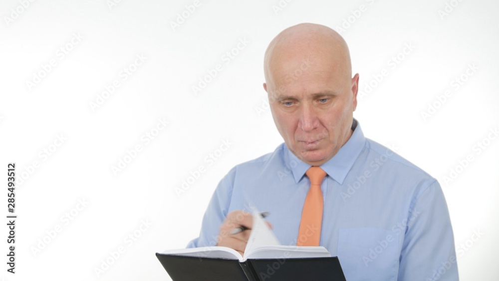 Image with a Confident Businessman Looking in Agenda Reading Financial Notes Image with a Confident Businessman Looking in Agenda Reading Financial Notes