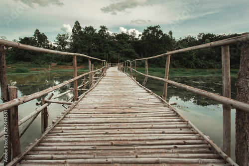 Wooden bridge made of bamboo across the water. The concept for the building project.