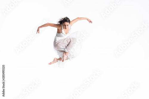 beautiful, graceful ballerina in white dress jumping in dance isolated on white photo