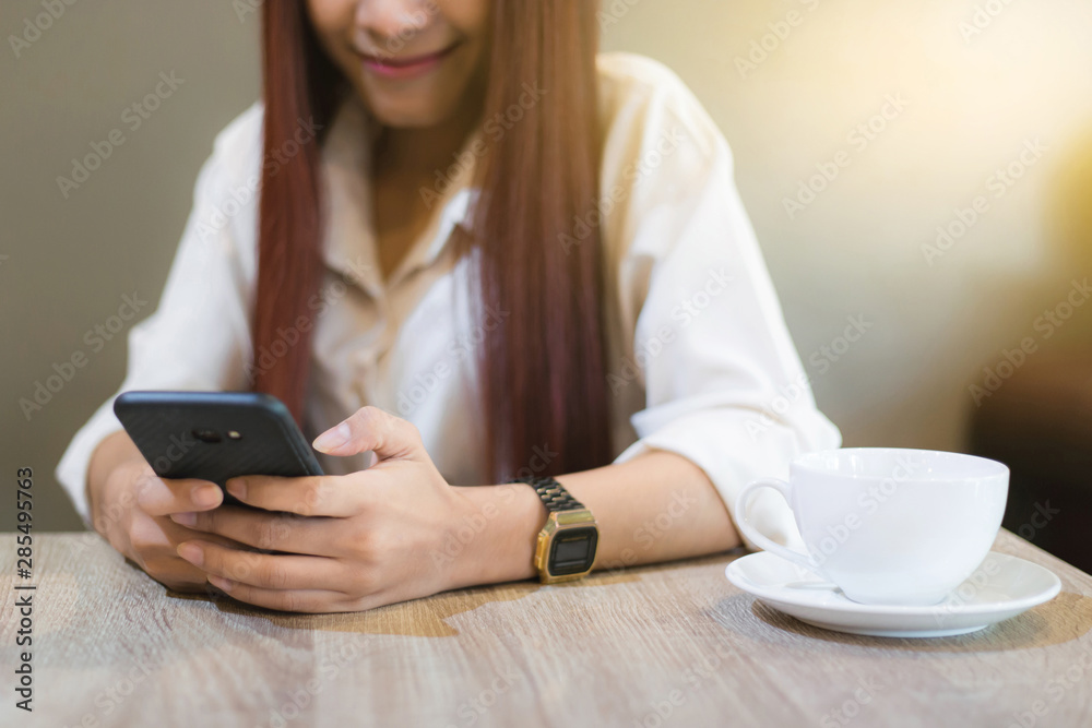 Woman asian are playing a social on the phone while drinking coffee in a cafe. Holiday ideas, Vintage style picture. Woman asian are playing a social on the phone while drinking coffee in a cafe. Holiday ideas, Vintage style picture.