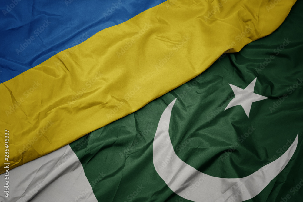 waving colorful flag of pakistan and national flag of ukraine.