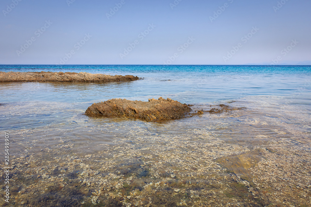 Calm translucent turquoise sea, beautiful rocky reef and distant horizon Calm translucent turquoise sea, beautiful rocky reef and distant horizon