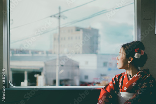  Asian woman wearing kimono traveling by the japan classic train sitting near the window