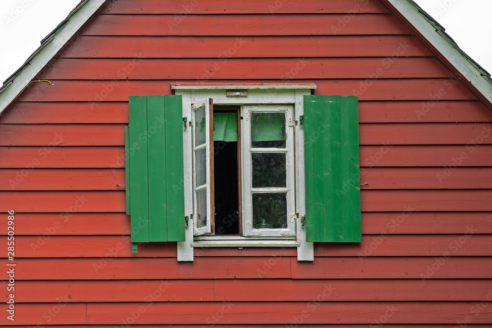 Window with green sun blinds on the red wall of wooden Scandinavian style house, Norway Window with green sun blinds on the red wall of wooden Scandinavian style house, Norway