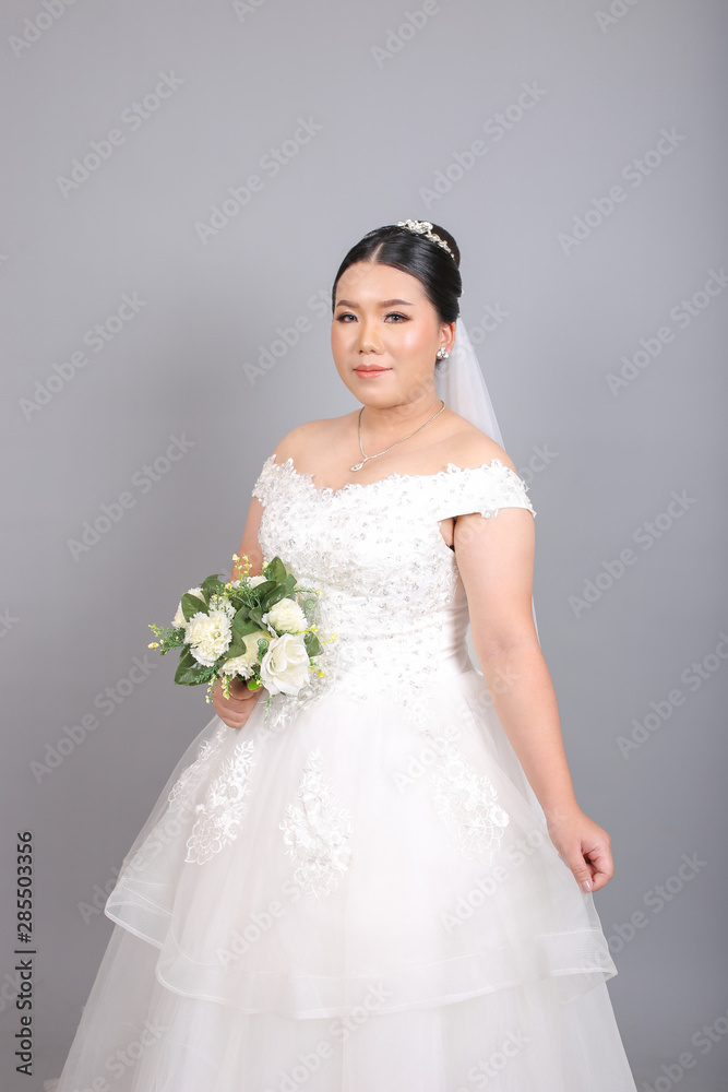 Fat Asian bride holding a bouquet of flower in studio Fat Asian bride holding a bouquet of flower in studio
