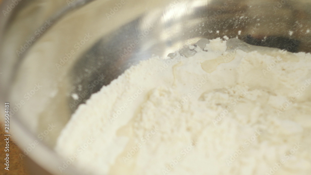 woman mother or daughter on the kitchen table makes domestic food pizza, hands work and pushing stir knead the dough, selective focus dolly shot