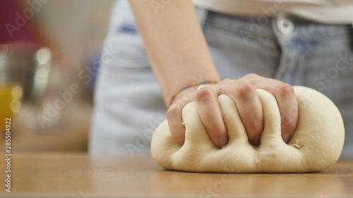 woman on the kitchen table makes domestic food pizza, hands work and pushing stir knead the dough, selective focus dolly shot © smartbobert