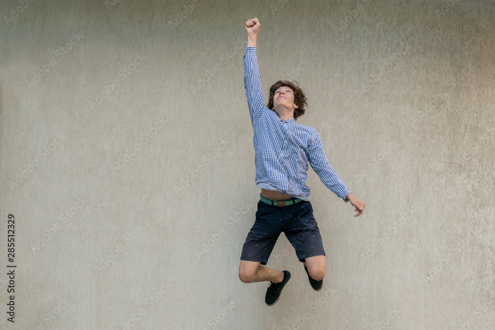 young man jumping high, winning or success gesture sign