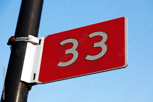 a red sign with the figure thirty-three in reflex material found at Umedalen in Umea