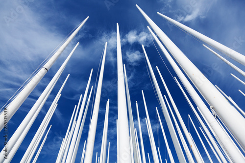 Umea, Sweden - July 25, 2019: lots of flagpoles after the Nolia fair in the fields near the fairgrounds with summer blue background