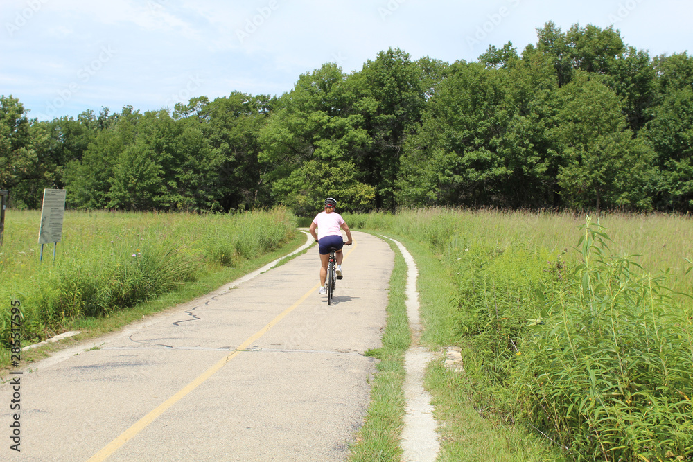 Female cyclist in a meadow on the North Branch Trail in Morton Grove, Illinois in summer Female cyclist in a meadow on the North Branch Trail in Morton Grove, Illinois in summer