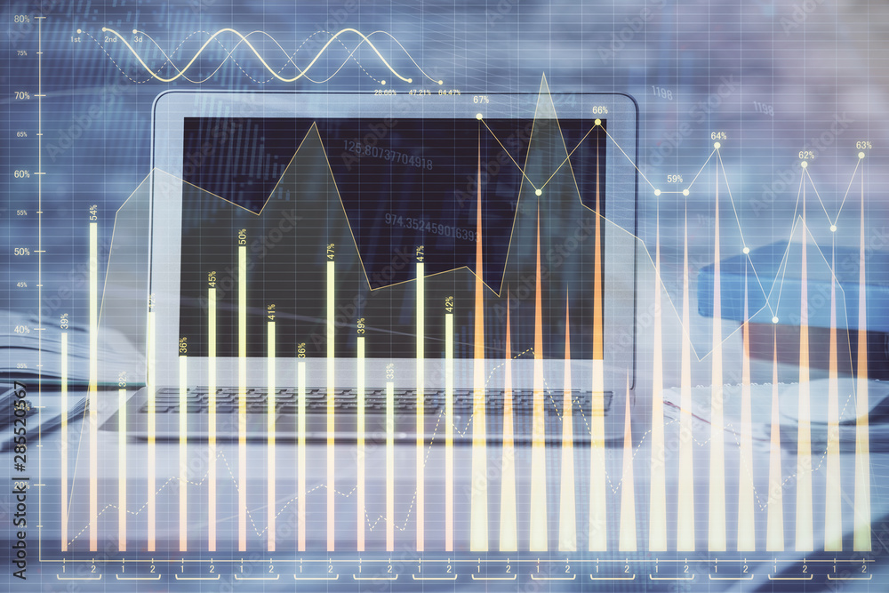 Financial chart drawing and table with computer on background. Double exposure. Concept of international markets. Financial chart drawing and table with computer on background. Double exposure. Concept of international markets.