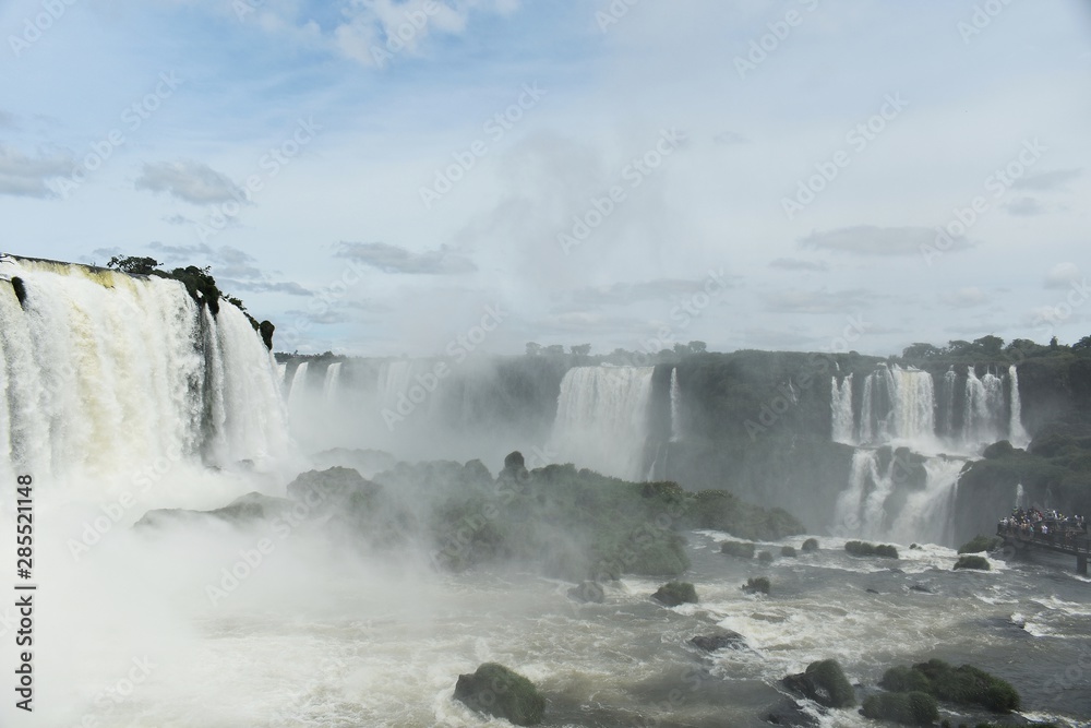 Iguazu Falls or Iguaçu Falls are waterfalls of the Iguazu River on the border of the Argentine and Brazil. Together, they make up the largest waterfall system in the world. Iguazu Falls or Iguaçu Falls are waterfalls of the Iguazu River on the border of the Argentine and Brazil. Together, they make up the largest waterfall system in the world.