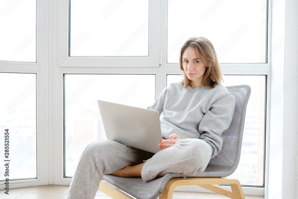 Smiling woman working on laptop in pyjamas Smiling woman working on laptop in pyjamas