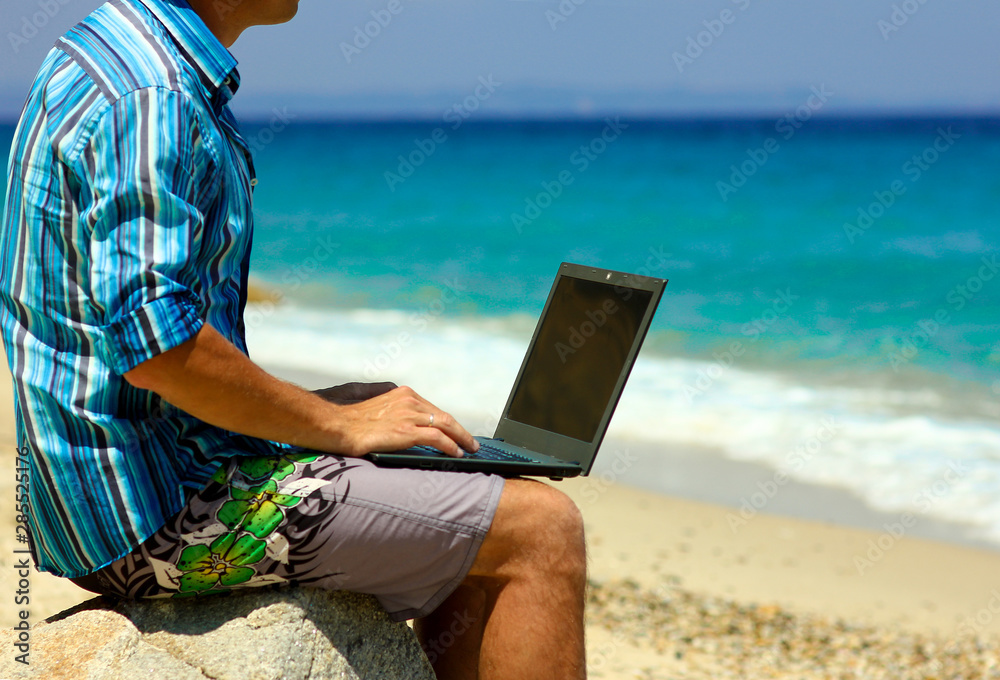 man with laptop by the sea