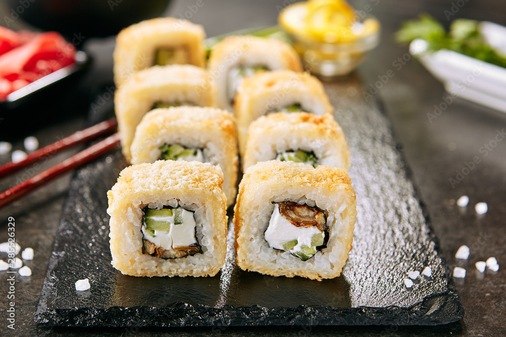 UnagTempura Uramaki Sushi Rolls with Eel on Black Background UnagTempura Uramaki Sushi Rolls with Eel on Black Background